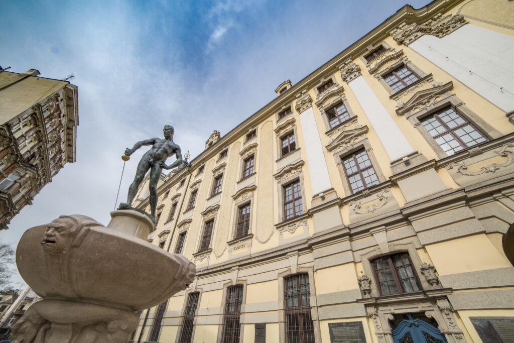 Widok od dołu na gmach główny oraz szermierza